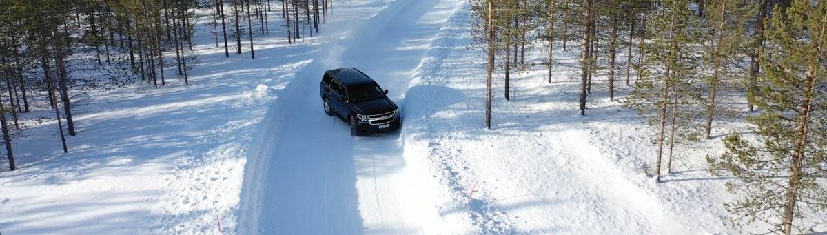 Внедорожник Chevrolet Tahoe движется по заснеженной лесной дороге в Швеции во время зимней программы испытаний